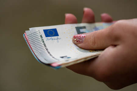Selective focus on detail of EURO banknotes. Counting or giving EURO banknotes. World money concept, inflation and economy conceptの写真素材