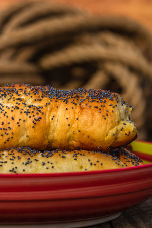 Sausages baked in dough sprinkled with salt and poppy seeds in a rustic composition. Sausages rolls,...