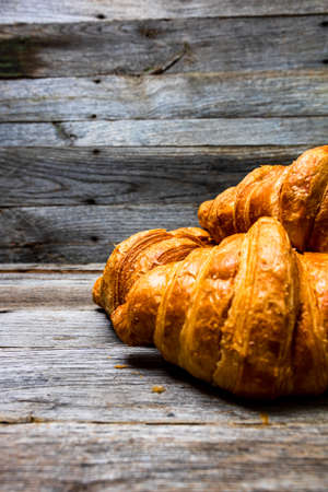 Delicious, fresh croissants isolated on wooden board. French breakfast concept.の写真素材
