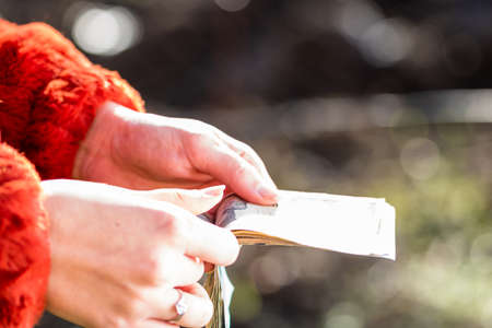 Selective focus on detail of USD banknotes. Counting or giving United States Dollars banknotes. World money concept, inflation and economy conceptの写真素材