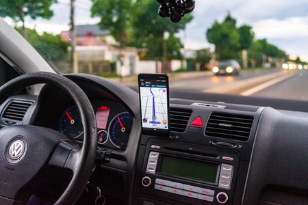 Driving and using waze maps application on smartphone on car dashboard, Driver using Waze maps app...