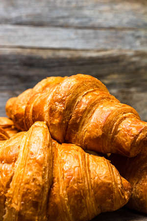 Delicious, fresh croissants isolated on wooden board. French breakfast concept.の写真素材