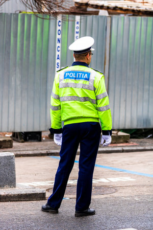 Police agent, Romanian Traffic Police (Politia Rutiera) directing traffic during  rush hour in...
