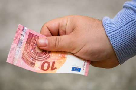 Selective focus on detail of EURO banknotes. Counting or giving EURO banknotes. World money concept, inflation and economy conceptの写真素材