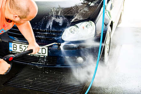 Washing and cleaning car in self service car wash station. Car washing using high pressure water in Bucharest, Romania, 2021のeditorial素材