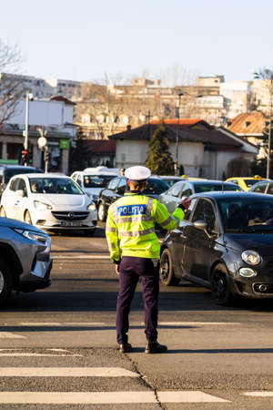 Police agent, Romanian Traffic Police (Politia Rutiera) directing traffic during  rush hour in downtown Bucharest, Romania, 2021のeditorial素材