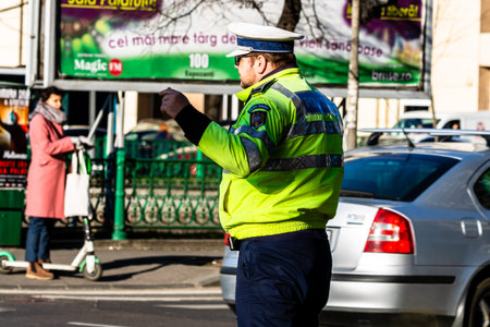 Police agent, Romanian Traffic Police (Politia Rutiera) directing traffic during  rush hour in...