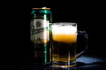 Can of Staropramen beer and beer glass on dark background. Illustrative editorial photo shot in Bucharest, Romania, 2021のeditorial素材
