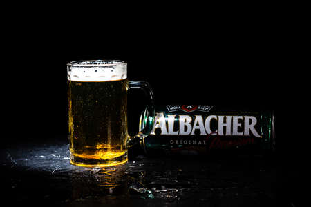 Can of Albacher beer and beer glass on dark background. Illustrative editorial photo shot in Bucharest, Romania, 2021のeditorial素材