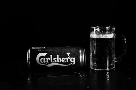 Can of Carlsberg beer and beer glass on dark background. Illustrative editorial photo shot in Bucharest, Romania, 2021のeditorial素材