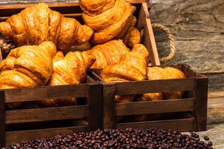 Freshly baked golden brown French croissants. Tasty baked croissants, warm buttery croissants with coffee, breakfast conceptの写真素材