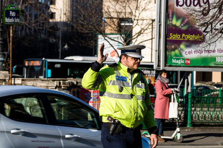 Police agent, Romanian Traffic Police (Politia Rutiera) directing traffic during  rush hour in...