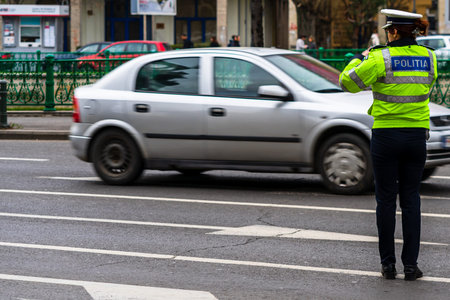 Police agent, Romanian Traffic Police (Politia Rutiera) directing traffic during  rush hour in...