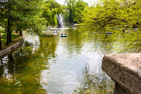People on pedal boat on lake in Cismigiu Park, Bucharest, Romania, 2020. People walking, having fun, enjoying outdoor in park after quarantine or restrictions of coronavirus.のeditorial素材