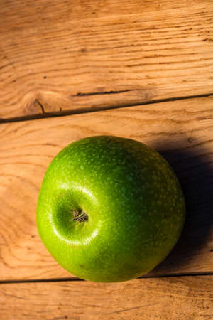 Tasty organic green juicy green apples on a rustic wooden backgroundの写真素材