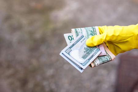 Hand with gloves receiving, giving or holding USD EURO banknote. World money conceptの写真素材