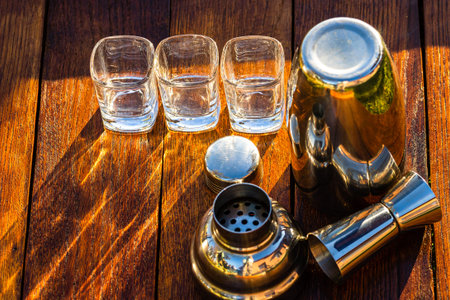 Bar ustensils, drink concept. Cocktail shaker accessories on a wooden board.