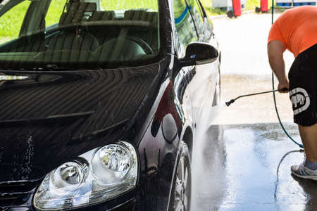 Washing and cleaning car in self service car wash station. Car washing using high pressure water in Bucharest, Romania, 2021のeditorial素材