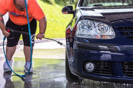 Washing and cleaning car in self service car wash station. Car washing using high pressure water in Bucharest, Romania, 2021のeditorial素材