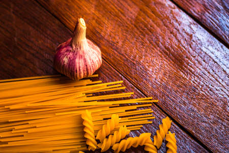 Spaghetti pasta and garlic on wooden tableの写真素材