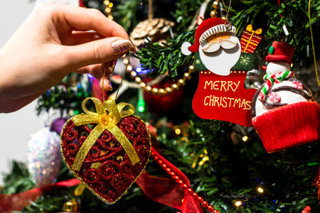 Hanging Christmas decorations and ornaments in the Christmas tree