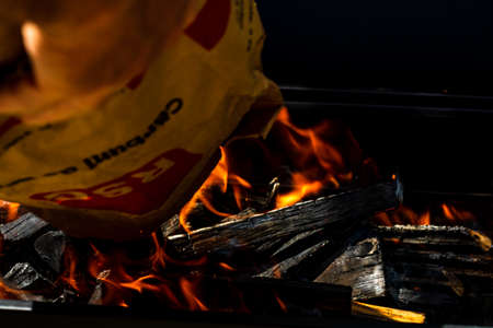 Barbecue grill pit with glowing and flaming hot open fire with red flame, hot charcoal briquettes and embersの写真素材