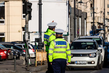 Police agent, Romanian Traffic Police (Politia Rutiera) directing traffic during  rush hour in downtown Bucharest, Romania, 2021のeditorial素材