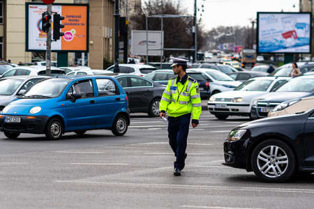 Police agent, Romanian Traffic Police (Politia Rutiera) directing traffic during  rush hour in downtown Bucharest, Romania, 2021のeditorial素材
