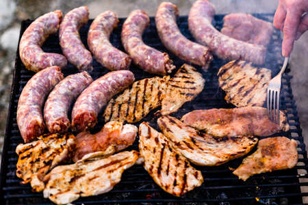 Grilling sausages and pork chops on barbecue grill. BBQ in the gardenの写真素材