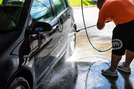 Washing and cleaning car in self service car wash station. Car washing using high pressure water in Bucharest, Romania, 2021のeditorial素材