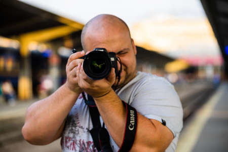 Young photographer taking pictures on the platform of Bucharest North Railway Station (Gara de Nord)のeditorial素材