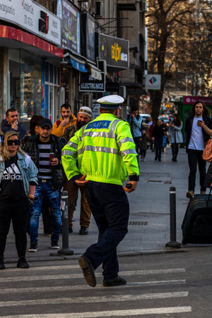 Police agent, Romanian Traffic Police (Politia Rutiera) directing traffic during  rush hour in...