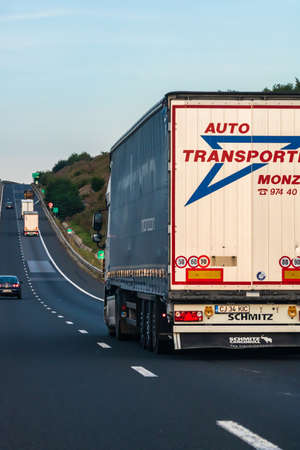 Side view of loaded European truck in motion on asphalt road, transportation and delivery concept. Detail on delivery truck. Bucharest, Romania, 2020のeditorial素材