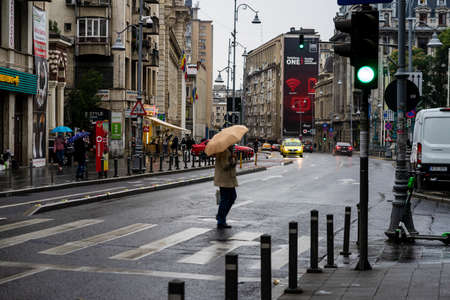 People with umbrella on the street on a rainy day in Bucharest, Romania, 2021のeditorial素材