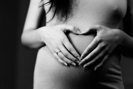 Pregnant woman making a heart on her belly