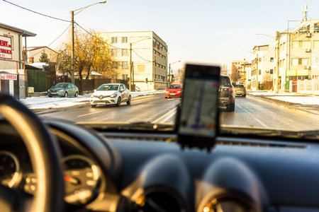 Using waze maps application on smartphone in car dashboard. Driver using maps app for showing the...