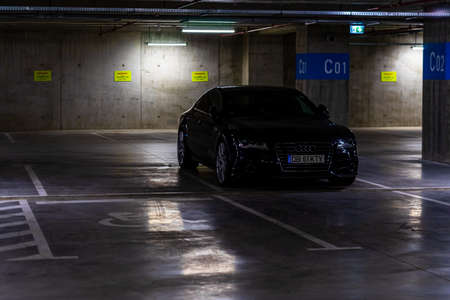 Parking garage interior with a few parked cars. Underground parking garage in Bucharest, Romania, 2021のeditorial素材