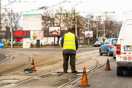 Worker arranging traffic cone on tram railway in Bucharest, Romania, 2021のeditorial素材