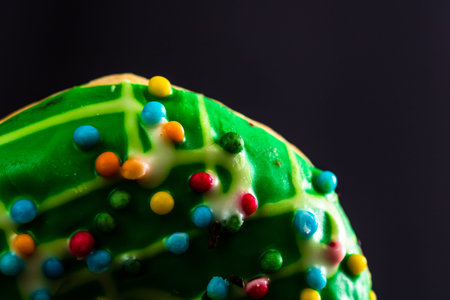 Green glazed donut with sprinkles isolated. Close up of colorful donut.