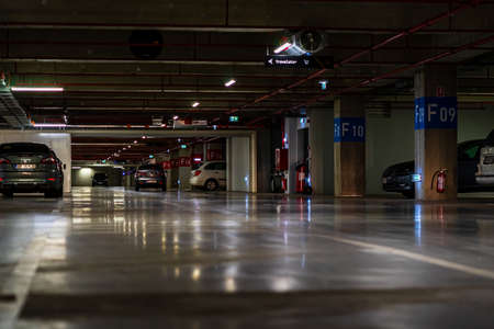 Parking garage interior with a few parked cars. Underground parking garage in Bucharest, Romania, 2021のeditorial素材