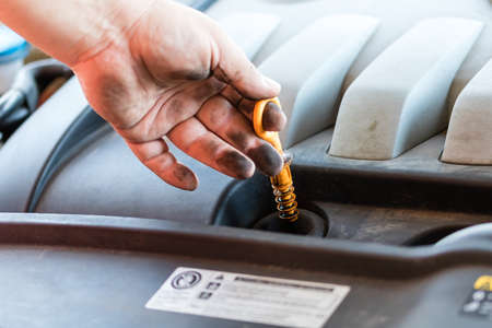 Car mechanic checking the engine oil levelのeditorial素材