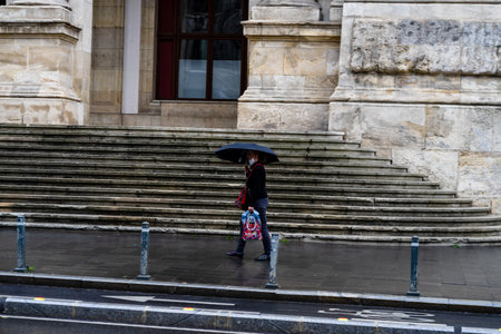 People with umbrella on the street on a rainy day in Bucharest, Romania, 2021のeditorial素材