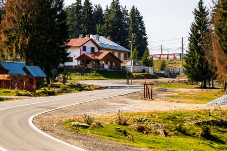 View of mountain road thorugh houses and trees in Bihor, Romania, 2021のeditorial素材