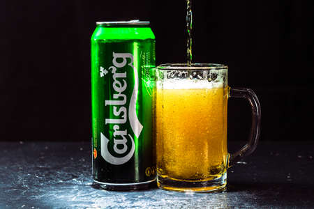 Can of Carlsberg beer and beer glass on dark background. Illustrative editorial photo shot in Bucharest, Romania, 2021のeditorial素材