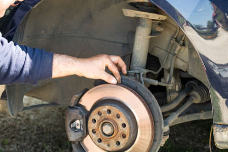 Mechanic cleaning and fixing the brake system of a car in Romania, Targoviste, 2021のeditorial素材