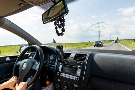 Driving and using waze maps application on smartphone on car dashboard,  Bucharest, Romania, 2021のeditorial素材