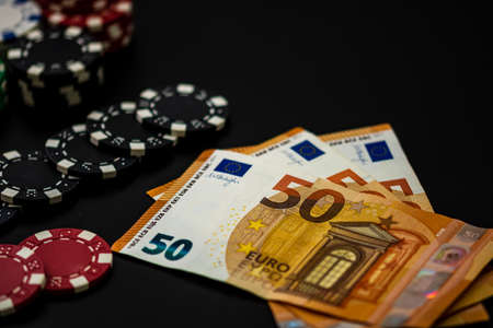 Stacks of poker chips with money and cardsの写真素材