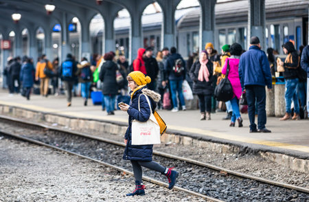 Travelers and commuters waiting for a train on the train platform of Bucharest North Railway Station...