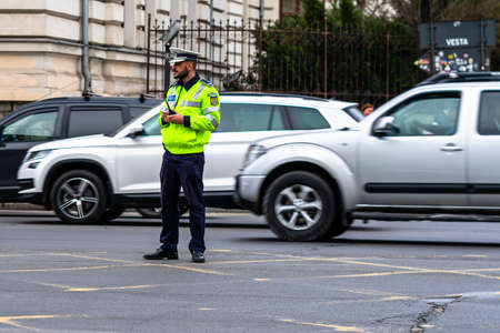 Police agent, Romanian Traffic Police (Politia Rutiera) directing traffic during  rush hour in downtown Bucharest, Romania, 2021のeditorial素材