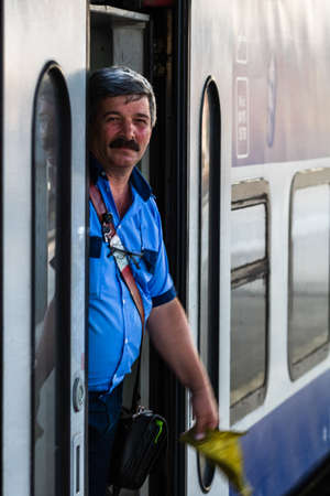 Railworker, train staff signaling for train conductor in Bucharest, Romania, 2022のeditorial素材